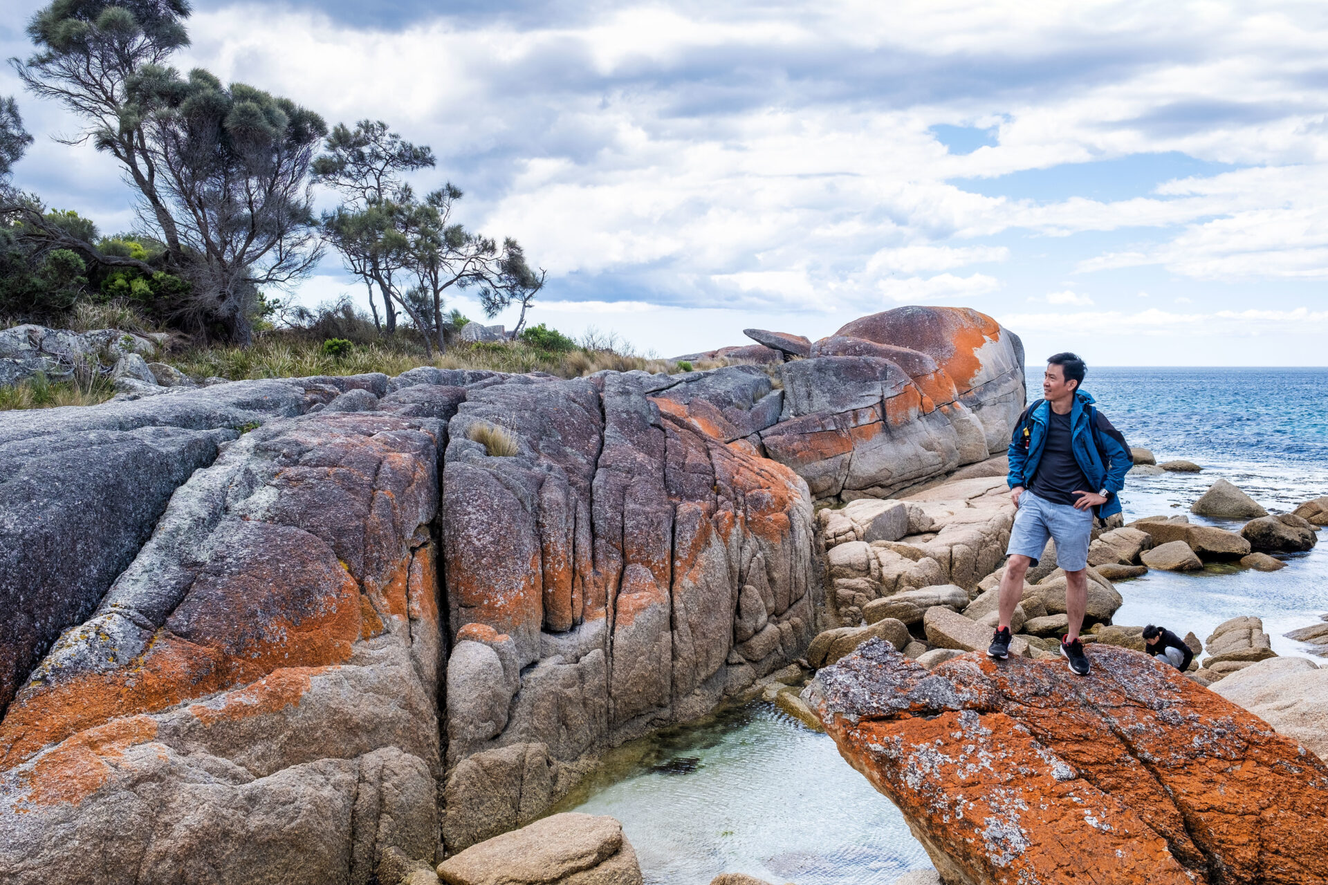 An Asian male is posing for the camera in Bay of Fire in Tasmania, Australia